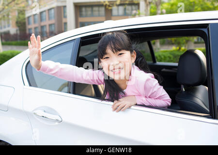 Cute little Chinese girl leaning out de fenêtre de voiture et forme Banque D'Images