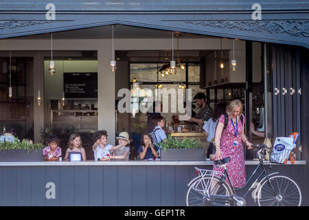 Les enfants prendre une collation dans un café en plein air dans la région de Cambridge. Banque D'Images