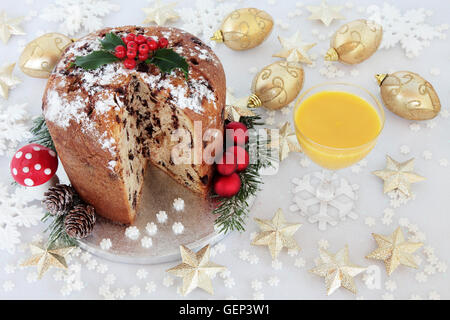 Panettone au chocolat gâteau de Noël avec le houx et de poule et de l'or et blanc décorations babiole. Banque D'Images