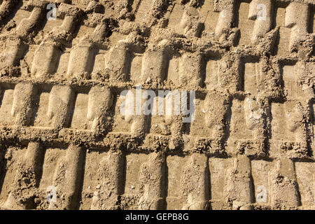 Arrière-plan avec des traces de pas dans le sable de machinerie lourde Banque D'Images