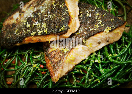 Close up de filets de poisson grillé avec la peau croustillante sur un lit de salicornes. Banque D'Images