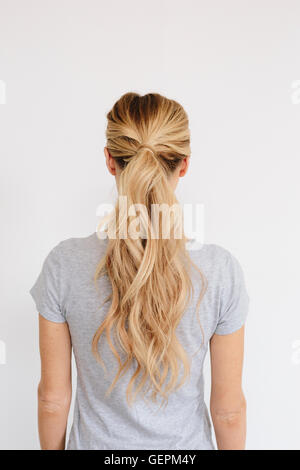 Une jeune femme aux longs cheveux blonds attachés en une queue de cheval. Vue arrière. Banque D'Images