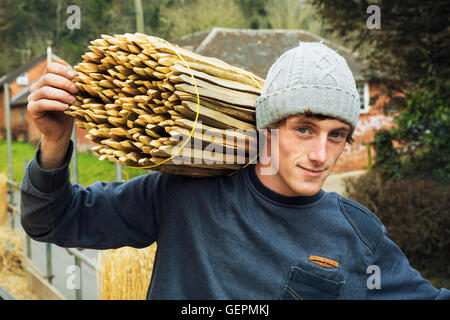Thatcher portant un paquet de chevilles de bois utilisé pour un toit de chaume. Banque D'Images
