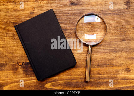 Loupe loupe et ordinateur portable sur un bureau en bois, vue du dessus, la recherche et l'étude de concept Banque D'Images