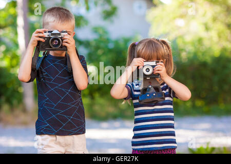 Petit garçon et fille l'apprentissage de l'utilisation de l'appareil photo Banque D'Images