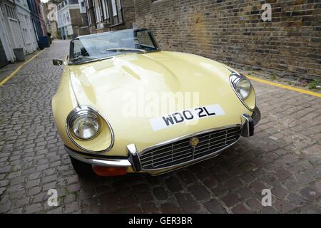 Route jaune Jaguar E-type V 12 stationnée sur un mews pavé à Londres Banque D'Images