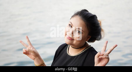 Young Asian woman making V part sign Banque D'Images