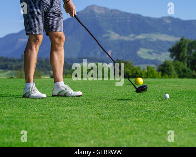 Photo d'un golfeur mâle pris le départ sur un parcours de golf sur un beau jour. Banque D'Images