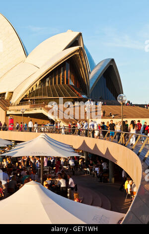 Rencontre des gens dans les bars le long du quai du port de Sydney à côté sous l'opéra de Sydney. Banque D'Images