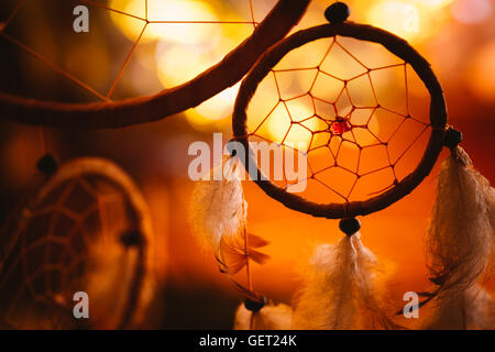 Photo en noir et blanc d'un Dream Catcher au coucher du soleil violet fond sombre. Banque D'Images