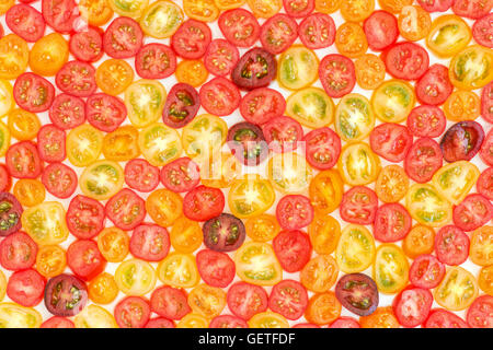 Solanum lycopersicum. Tranches de tomate cerise mini variétés sur fond blanc Banque D'Images