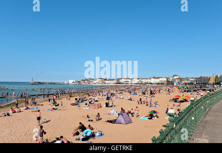 Les vacanciers profiter du soleil, de la mer et du sable, à la célèbre plage de Margate, avec ciel bleu et l'eau bleu clair. Banque D'Images