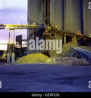 Crépuscule voir des matières premières et des silos à l'usine de ciment. Banque D'Images