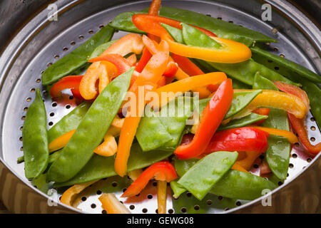 Neige et poivron sauté de pois en passoire en acier inoxydable Banque D'Images