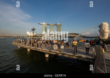 Année 2016. Grande foule de touristes visitant la zone de la baie flottante Merlion pour prendre des photos ou profiter du paysage de Marina Bay Sands région. Singapour. Banque D'Images