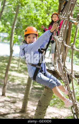 Happy Chinese Children playing in tree top adventure park Banque D'Images