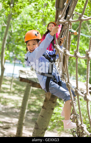 Happy Chinese Children playing in tree top adventure park Banque D'Images