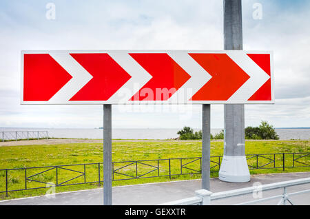 Tour dangereux. Flèche rouge et blanc dépouillé. Road sign in summer city Banque D'Images