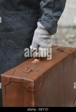 Immigrants pauvres avec valise en cuir et gants cassé pendant le voyage à l'étranger Banque D'Images