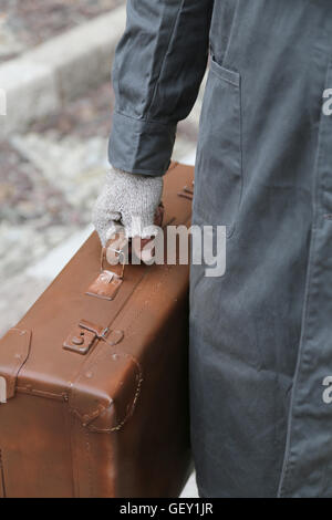 Immigrants pauvres avec le vieux cuir valise cassée et des gants pendant le voyage à l'étranger en hiver Banque D'Images