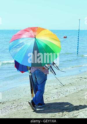 La mauvaise couleur de colporteur des parasols sur la plage en été Banque D'Images