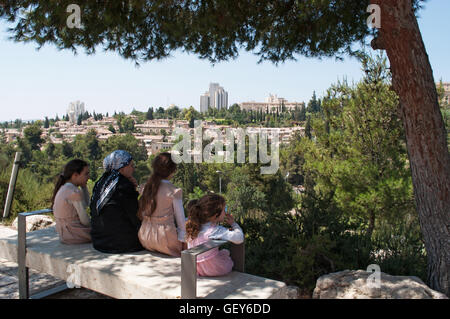 Jérusalem : une famille de juifs orthodoxes assis à l'ombre en profitant de la vue des Michkenot Sha'ananim, le premier quartier juif hors les murs Banque D'Images