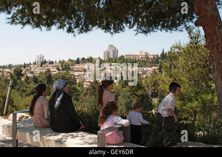 Jérusalem : une famille de juifs orthodoxes assis à l'ombre en profitant de la vue des Michkenot Sha'ananim, le premier quartier juif hors les murs Banque D'Images