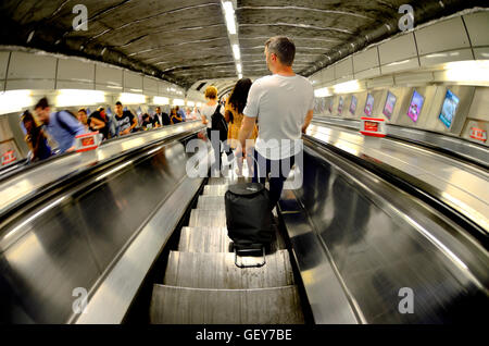 Homme avec une assurance de descendre un escalator dans le métro / Tube Banque D'Images