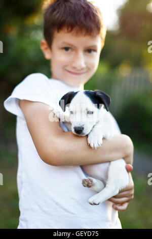 Happy little boy holding Jack Russell Terrier piscine pour enfants Banque D'Images