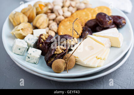 Assiette de fromage avec des craquelins, des dates et des écrous Banque D'Images