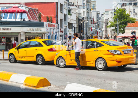 Istanbul, Turquie - 1 juillet 2016 : chauffeur de taxi jaune près de voitures sur la place Taksim. Paysage urbain d'Istanbul Banque D'Images