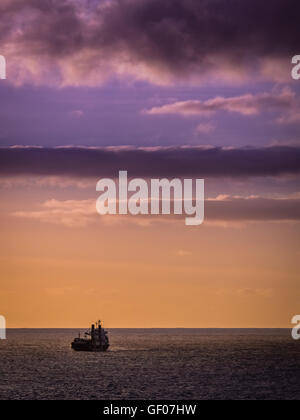 D'un cargo sur une mer calme avec un ciel nuageux au-dessus de l'océan sur la côte de Ponta Delgada, île de Sao Miguel, Açores, Portugal Banque D'Images