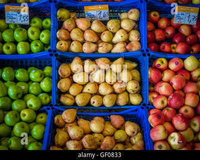 Jaune et vert frais poires et pommes rouges à vendre stockées dans des paniers en plastique bleu sur le marché local à Ponta Delgada, Sao Mi Banque D'Images
