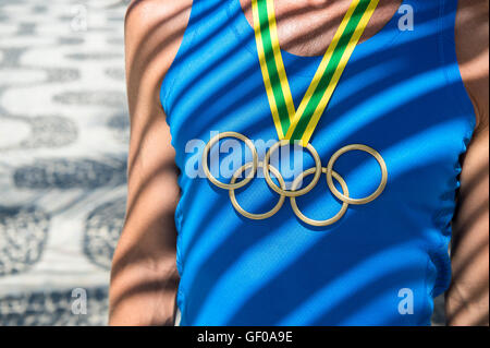 RIO DE JANEIRO - le 23 février 2015 : Athlète portant des anneaux olympiques médaille d'agir aux termes de palmier d'ombre. Banque D'Images