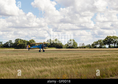 Un vintage biplan décollant de la piste d'herbe Banque D'Images