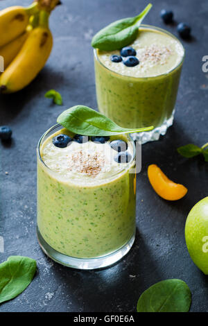 Super smoothie vert sain avec les épinards, la banane, amandes et noix, miel et bleuets. Selective focus Banque D'Images