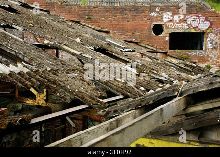 Sur toiture fibrociment ondulé endommagé bâtiment industriel abandonné. Banque D'Images