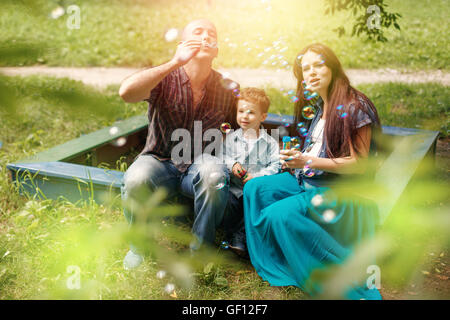 Famille heureuse à l'aire de jeux avec des bulles de savon. Focus sélectif. Banque D'Images