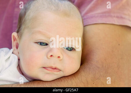 Portrait Of Cute 4 mois bébé nouveau-né garçon couché sur Père Arms Banque D'Images