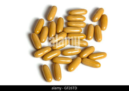 Studio shot vue ci-dessus des capsules de couleur moutarde épars répartis sur fond blanc Banque D'Images