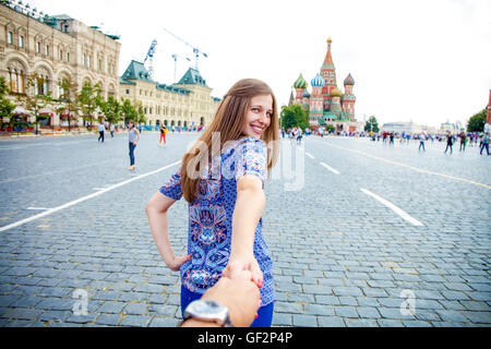 Suivez-moi. Jeune fille heureuse tire le gars part sur la Place Rouge à Moscou, Russie Banque D'Images