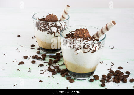 Cocktail au chocolat avec crème fouettée sur fond vert clair. Crémeux café dessert au chocolat. Banque D'Images