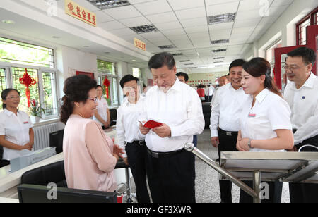 Tangshan, Province de Hebei en Chine. 28 juillet, 2016. Le président chinois Xi Jinping (C), qui est également secrétaire général du Parti communiste chinois (PCC) et président du Comité central de la Commission militaire centrale (CMC), parle avec une femme qui a besoin d'un service au service des affaires gouvernementales de l'Xiangfuli hall dans la communauté Tangshan, Chine du nord, dans la province du Hebei, le 28 juillet 2016. Credit : Lan Hongguang/Xinhua/Alamy Live News Banque D'Images