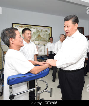 Tangshan, Province de Hebei en Chine. 28 juillet, 2016. Le président chinois Xi Jinping (R avant), qui est également secrétaire général du Parti communiste chinois (PCC) et président du Comité central de la Commission militaire centrale (CMC), des entretiens avec un patient paraplégique à la ville centre de réadaptation paraplégique à Tangshan, Province de Hebei en Chine du nord, le 28 juillet 2016. Credit : Xie Huanchi/Xinhua/Alamy Live News Banque D'Images