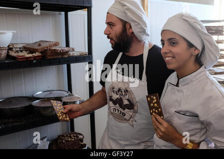 Jérusalem, Israël. 28 juillet, 2016. DANIEL (L) et EILYA (R) fabrication de chocolat au lait vegan à leur petit 'Panda' factory utilisant du lait de soja et l'huile de noix de coco dans une recette provenant de deux années d'expérimentation. Israël, considéré comme "la capitale du monde vegan', a la plus forte population végétalienne par habitant dans le monde. Environ 5  % ont renoncé à la viande, les produits laitiers et les œufs pour des raisons idéologiques. La tendance s'est également imposé dans la communauté orthodoxe où les nouveaux convertis utiliser sources juives d'argumenter contre la consommation de viande. Banque D'Images