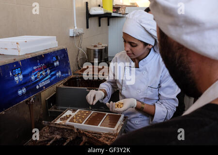 Jérusalem, Israël. 28 juillet, 2016. DANIEL (R) et EILYA (L) fabrication de chocolat au lait vegan à leur petit 'Panda' factory utilisant du lait de soja et l'huile de noix de coco dans une recette provenant de deux années d'expérimentation. Israël, considéré comme "la capitale du monde vegan', a la plus forte population végétalienne par habitant dans le monde. Environ 5  % ont renoncé à la viande, les produits laitiers et les œufs pour des raisons idéologiques. La tendance s'est également imposé dans la communauté orthodoxe où les nouveaux convertis utiliser sources juives d'argumenter contre la consommation de viande. Banque D'Images