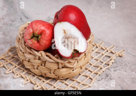 Fruits tropicaux Acmella oleracea (mal de dents, de l'usine, paracress electric daisy, le jambu) dans panier en osier sur la table de marbre. Selective Banque D'Images