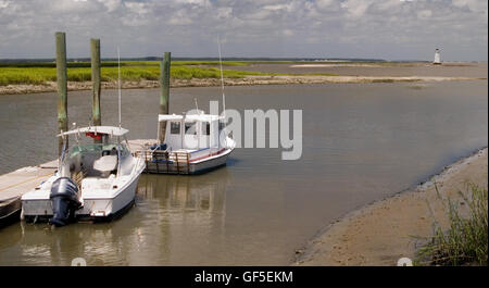 Deux bateaux flottent tranquillement à un petit quai sur une voie navigable intérieure près de Tybee Island, Caroline du Sud, USA. Banque D'Images