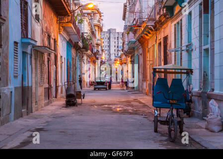 Un cycle rickshaw dans une rue de Centro Habana au crépuscule. La Havane, Cuba. Banque D'Images