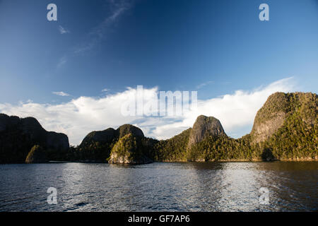 Îles calcaires escarpées entourant un lagon tropical, à distance à Wayag, Raja Ampat, en Indonésie. Banque D'Images
